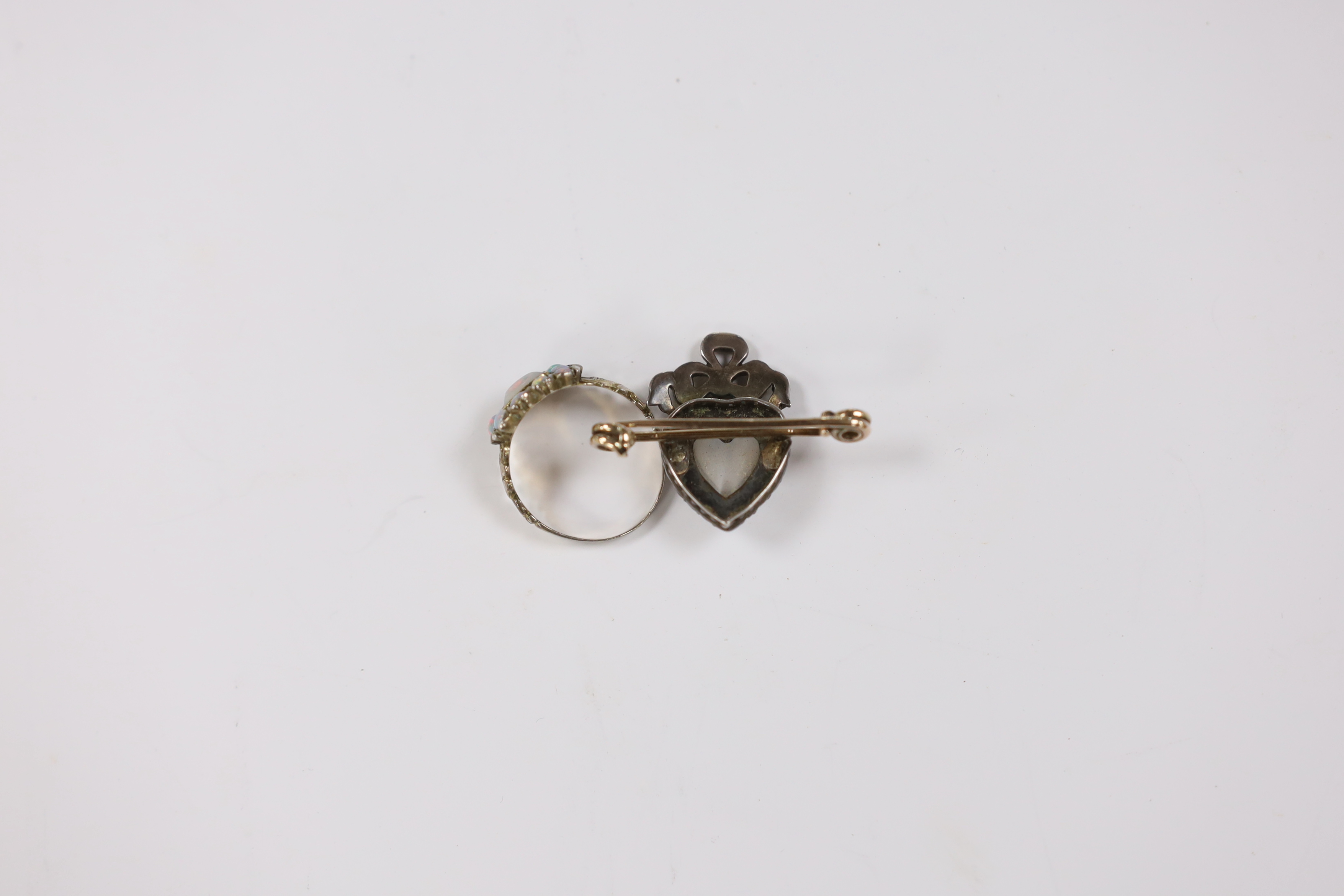 A Victorian yellow metal and white opal cluster set ring, size O and a similar moonstone and split pearl cluster set bar brooch with heart motif.